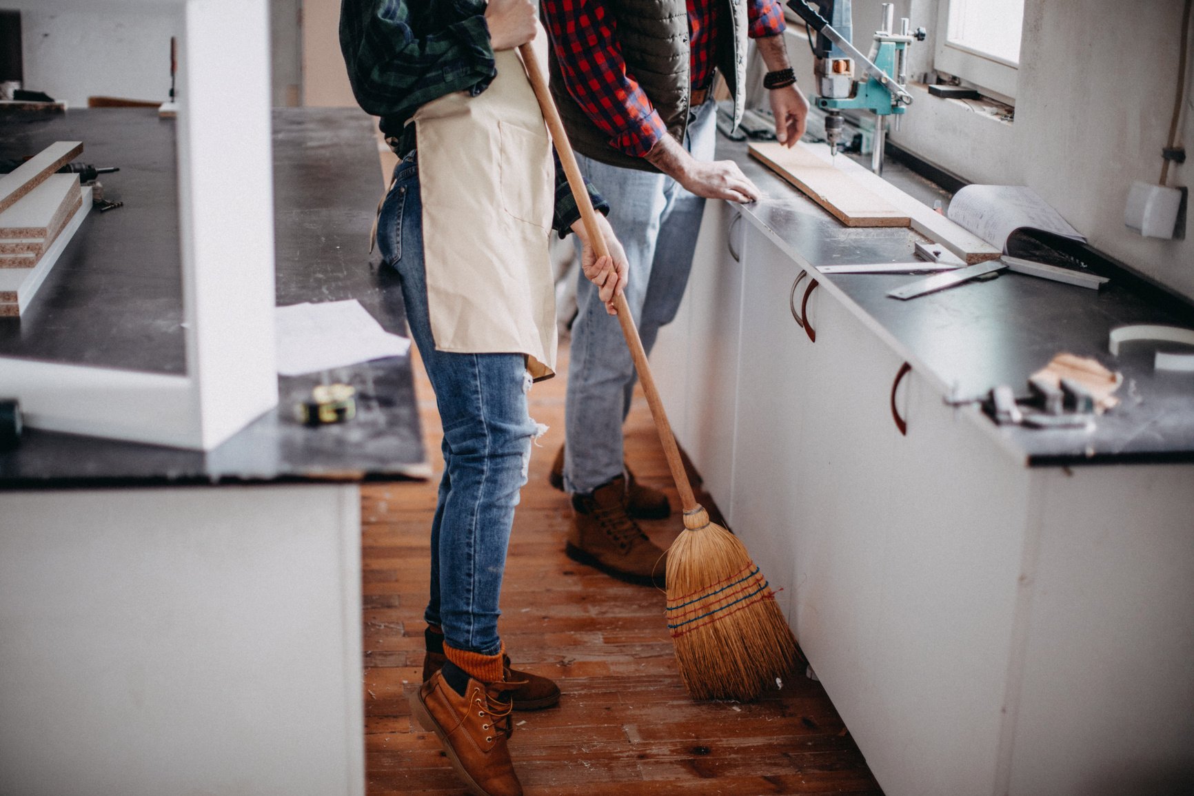 Young couple cleaning a construction workshop